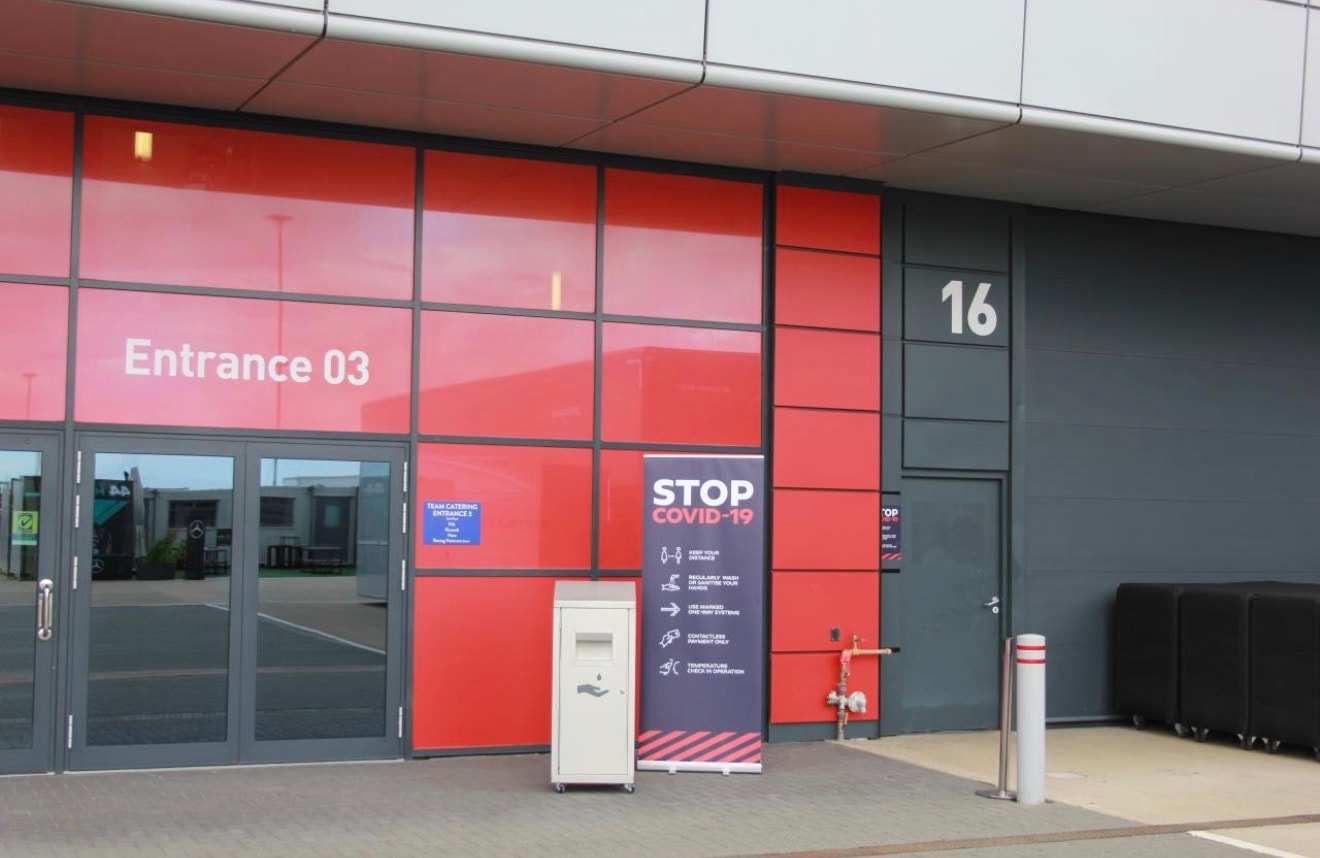 Freestanding hand-sanitiser unit positioned outside a Formula 1 facility at Silverstone Circuit