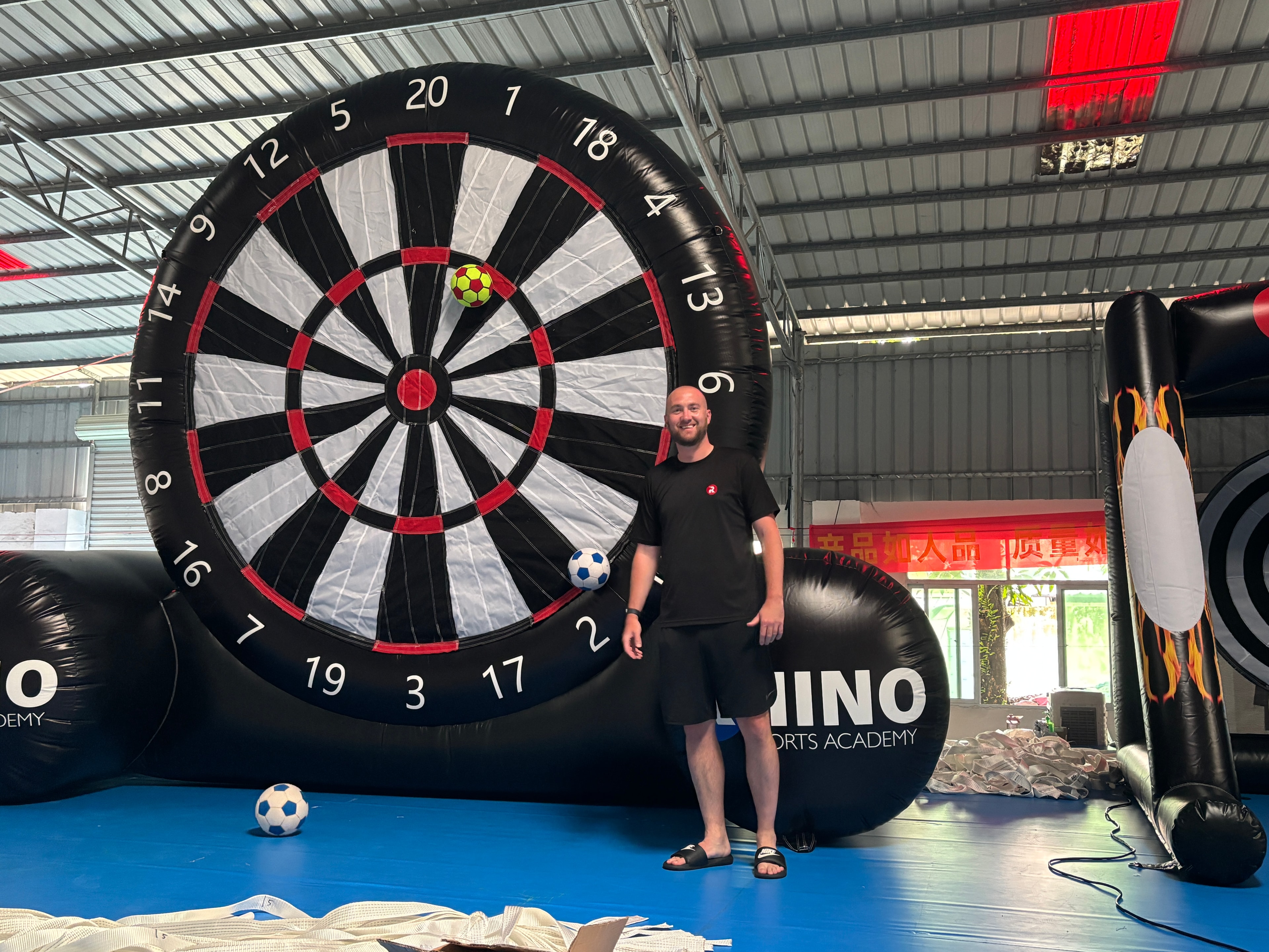 Rhino Sports Academy owner testing custom inflatable football dartboard during production in China.