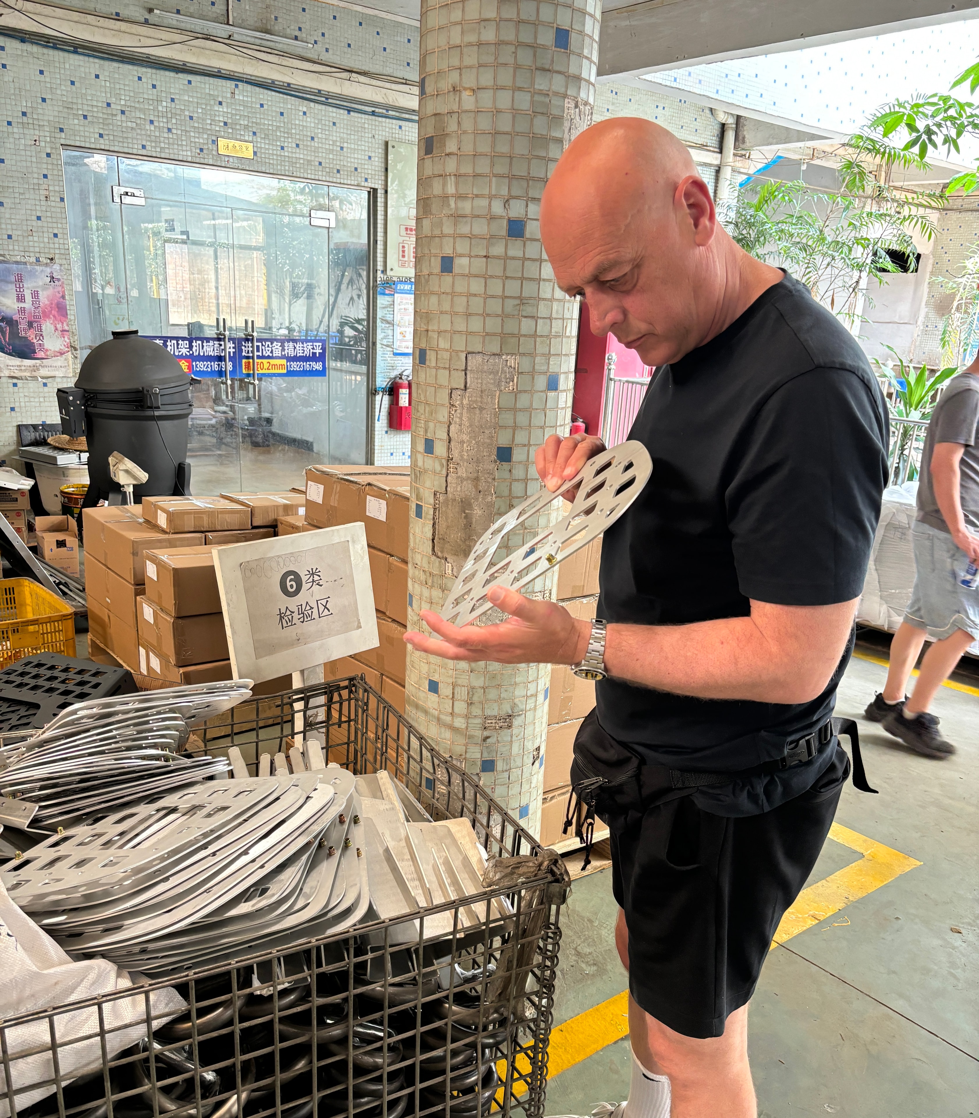 Colin Moore of Sauce Asia inspecting fabricated metal components during a quality control visit at a factory in China.