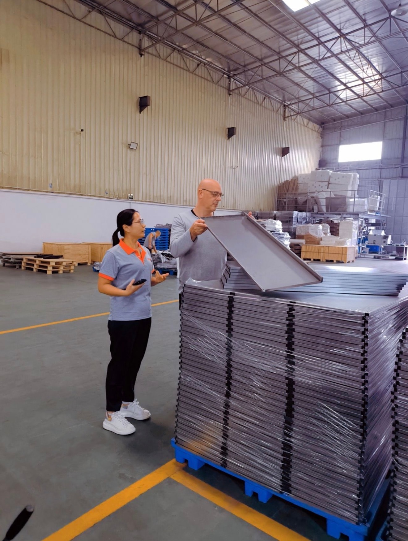 Colin Moore inspecting stacked sheet metal trays before shipment