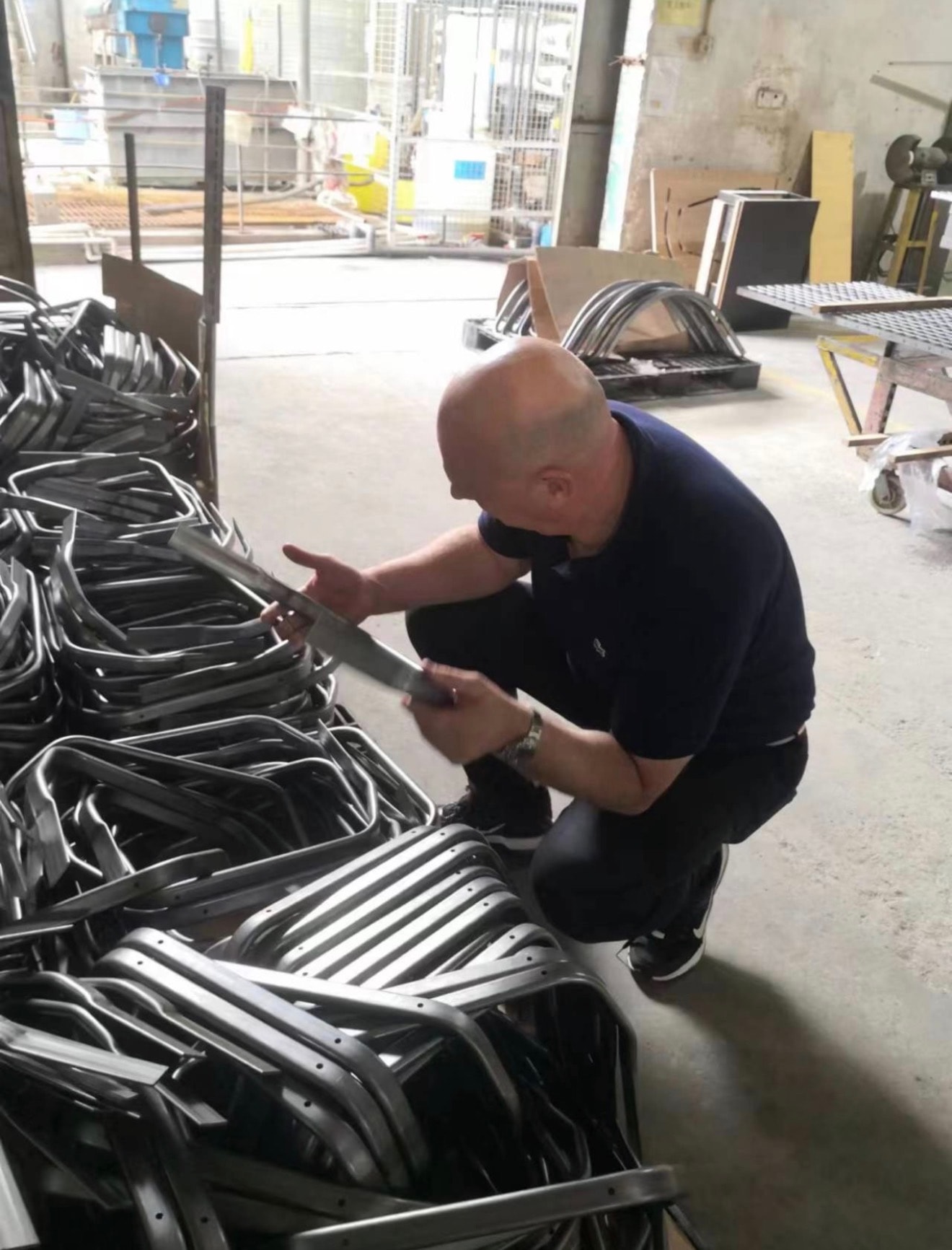 Colin Moore inspecting shelving components in a Chinese warehouse
