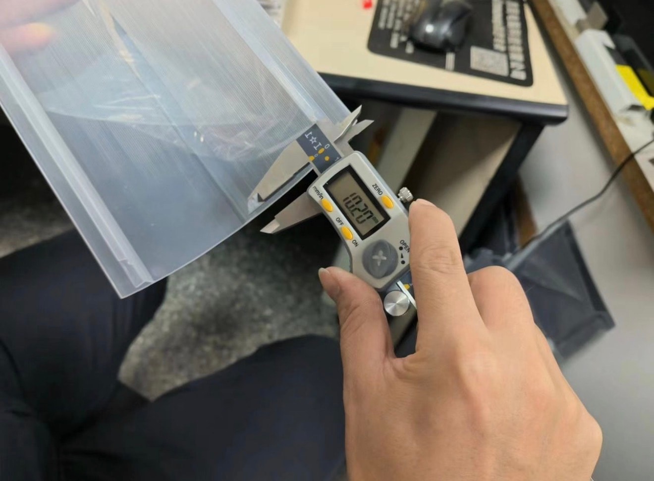 Digital calipers measuring a manufactured plastic component during a factory inspection in China